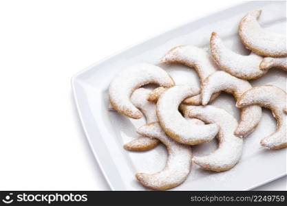 Traditional German or Austrian Vanillekipferl vanilla kipferl cookies on a plate isolated on white background. High quality photo. Traditional German or Austrian Vanillekipferl vanilla kipferl cookies on a plate isolated on white background
