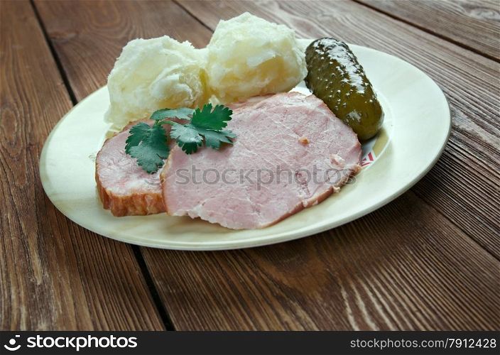 Traditional German Senfbraten with potatoes and pickles.