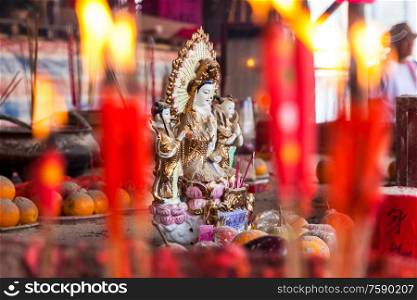 Traditional goddess figurine, offerings, incense sticks and red candles burning in a temple, Hong Kong, China, Asia