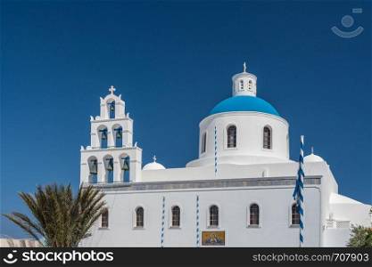 Traditional Greek Orthodox church in village of Oia on Santorini. Belltower and blue dome on Greek Orthodox church in Oia