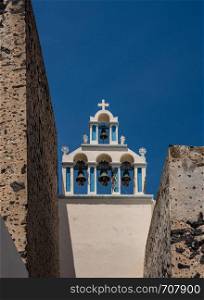 Traditional Greek Orthodox church with bell tower in village of Fira on Santorini. Belltower and bells on Greek Orthodox church in Fira