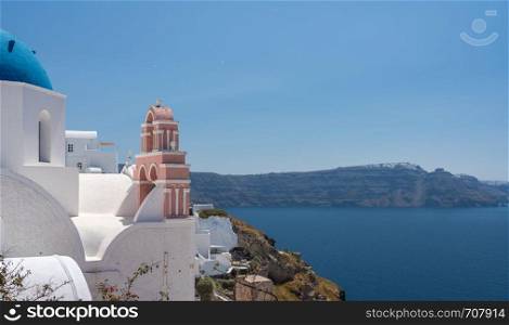 Traditional Greek Orthodox church with bell tower in village of Oia on Santorini. Belltower and bells on Greek Orthodox church in Oia