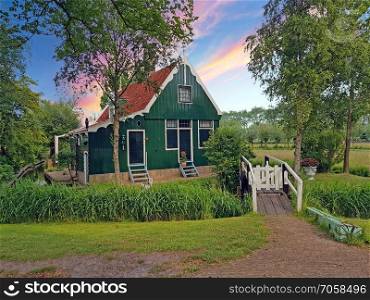 Traditional historical old dutch wooden house in the countryide from the Netherlands at sunset