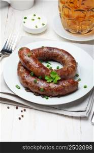 Traditional homemade coiled sausage with beer on wooden table