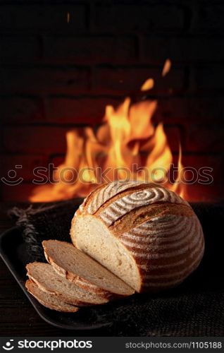 Traditional house bread on the table in front of a brick oven
