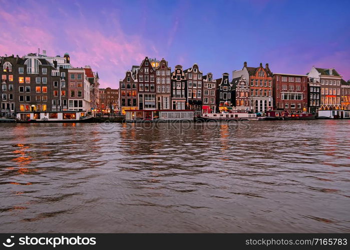 Traditional houses along the river Amstel in Amsterdam the Netherlands at sunset