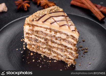 Traditional Hungarian Esterhazy cake, torte. Black background. Copy space. Esterhazy cake sliced on black plate close-up. Delicatessen sweet dessert with almond meringue dough and buttercream