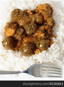 Traditional Indian mushroom curry with basmati rice and a fork