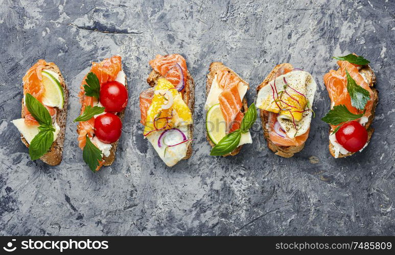 Traditional italian bruschetta.Open sandwich with salmon and vegetables. Assorted bruschetta with fish