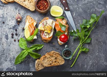 Traditional italian bruschetta.Open sandwich with salmon and vegetables. Open sandwich with salmon