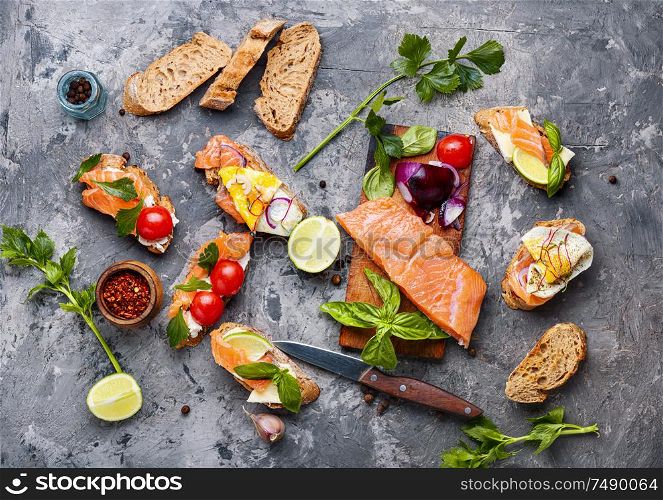 Traditional italian bruschetta or canape.Open sandwich with salmon and ingredients. Assorted bruschetta or canape