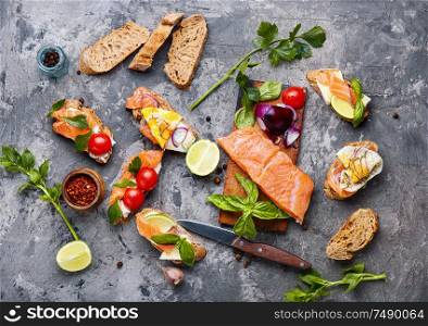 Traditional italian bruschetta or canape.Open sandwich with salmon and ingredients. Assorted bruschetta or canape
