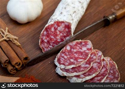 traditional Italian salame cured sausage sliced on a wood board