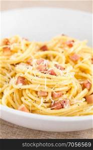 Traditional Italian Spaghetti Carbonara served on plate (Selective Focus, Focus on the front of the dish). Spaghetti Carbonara