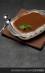 Traditional Italian Tiramisu dessert in glass baking dish on concrete background or table. Traditional Italian Tiramisu dessert in glass baking dish on concrete background