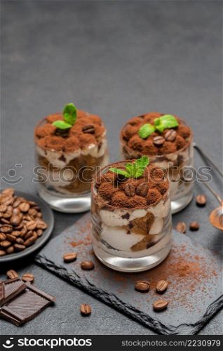 Traditional Italian Tiramisu dessert in glass baking dish on stone serving board with chalk inscription sign on wooden background or table. Traditional Italian Tiramisu dessert in glass baking dish on stone serving board with chalk inscription sign on wooden background