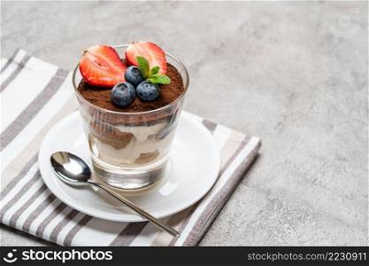 Traditional Italian Tiramisu dessert in glass baking dish on wooden background or table. Traditional Italian Tiramisu dessert in glass baking dish on wooden background