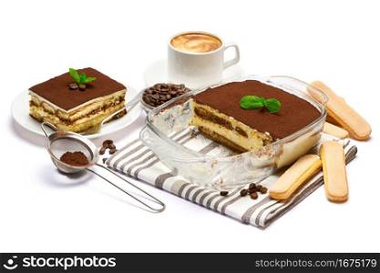 Traditional Italian Tiramisu dessert in glass baking dish, portion on plate and cup of coffee isolated on white background.. Traditional Italian Tiramisu dessert in glass baking dish, portion on plate and cup of coffee isolated on white background