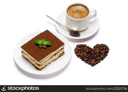 Traditional Italian Tiramisu square dessert portion on ceramic plate and heart shape made of coffee beans isolated on white background with clipping path embedded. Traditional Italian Tiramisu square dessert portion on ceramic plate and heart shape made of coffee beans isolated on white background with clipping path