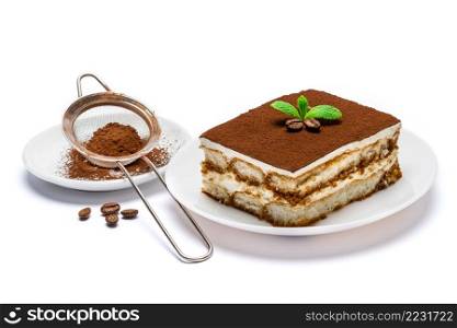 Traditional Italian Tiramisu square dessert portion on ceramic plate and strainer with cocoa powder isolated on white background. Traditional Italian Tiramisu square dessert portion on ceramic plate and strainer with cocoa powder isolated on white