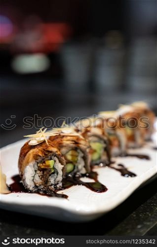 Traditional japanese food cuisine Unagi roll, japanese ell serve with japanese rice and avocado with special sauce.