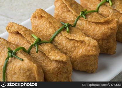 Traditional Japanese fried marinated tofu stuffed with rice, called inari age, close up