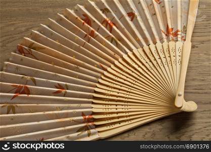Traditional Japanese hand fan decorated with autumn maple leaves