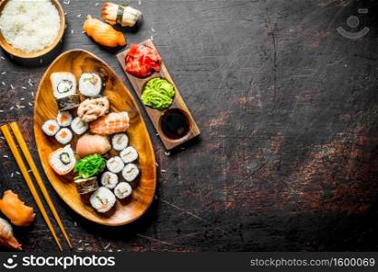 Traditional Japanese sushi and rolls with soy sauce and ginger. On dark rustic background. Traditional Japanese sushi and rolls with soy sauce and ginger.