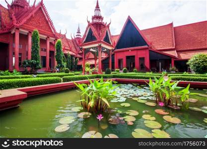 Traditional Khmer architecture and beautiful courtyard of the National Museum of Cambodia, lush pond with colorful lotus. Phnom Penh City, Cambodia. Bright sunlight. Public park, public museum.