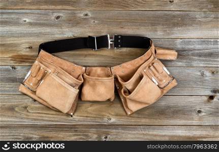 Traditional leather tool belt on rustic wooden floor.