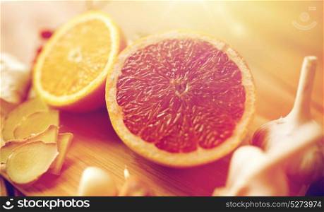 traditional medicine, cooking, food and ethnoscience concept - citrus fruits, ginger and garlic on wooden background. citrus fruits, ginger and garlic on wood