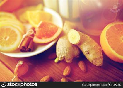 traditional medicine, healthcare and ethnoscience concept - ginger, citrus fruits, tea or honey on wooden table. ginger, citrus fruits, tea or honey on wood