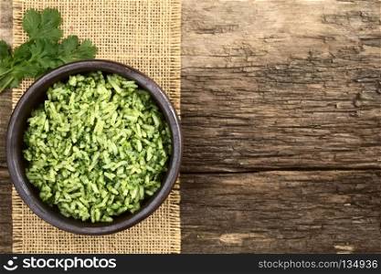 Traditional Mexican Arroz Verde green rice dish made of long-grain rice, spinach, cilantro and garlic, served in rustic bowl, photographed overhead with copy space (Selective Focus, Focus on the rice dish). Mexican Arroz Verde Green Rice Dish