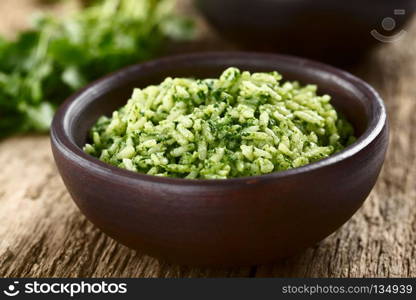 Traditional Mexican Arroz Verde green rice dish made of long-grain rice, spinach, cilantro and garlic, served in rustic bowl (Selective Focus, Focus in the middle of the image). Mexican Arroz Verde Green Rice Dish