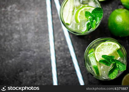 Traditional mojito with pieces of lime and mint. On a black background. High quality photo. Traditional mojito with pieces of lime and mint.