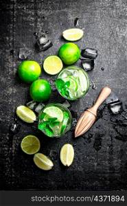 Traditional mojito with pieces of lime and mint. On a black background. High quality photo. Traditional mojito with pieces of lime and mint.