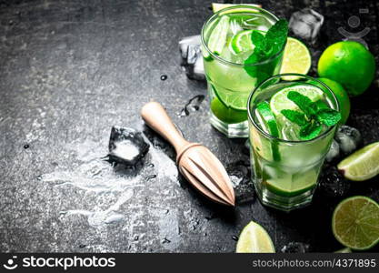 Traditional mojito with pieces of lime and mint. On a black background. High quality photo. Traditional mojito with pieces of lime and mint.