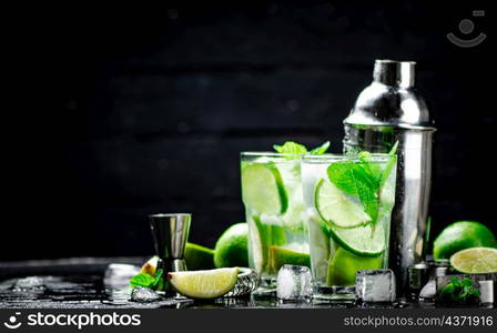 Traditional mojito with pieces of lime and mint. On a black background. High quality photo. Traditional mojito with pieces of lime and mint.