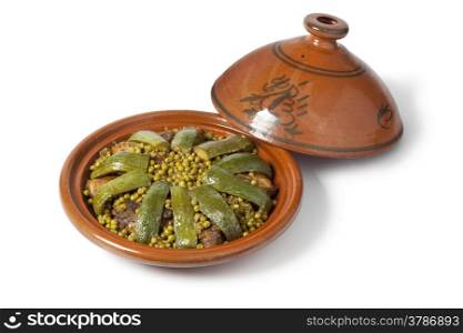 Traditional Moroccan dish with lamb, peas and courgette on white background