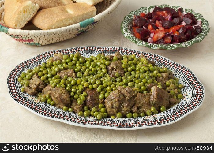 Traditional Moroccan dish with meat, peas, beet salad and bread close up