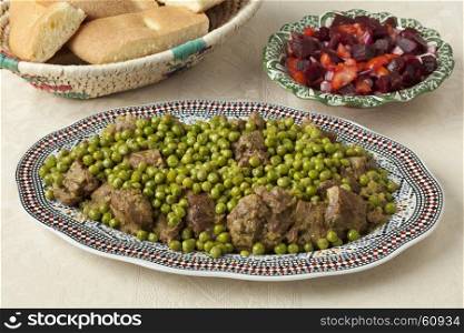 Traditional Moroccan dish with meat, peas, beet salad and bread close up