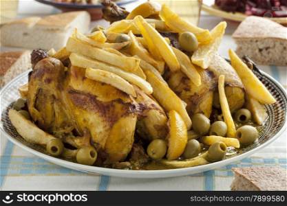 Traditional moroccan stuffed chicken with french fries, olives and preserved lemon