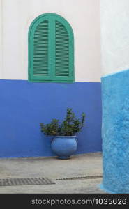 Traditional Moroccan window protected with green shutters in Asilah, Morocco