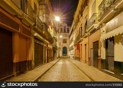 Traditional narrow street in the old historic part of the city at night. Sevilla, Spain. Andalusia.