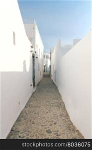 Traditional narrow street in the town Fira on the island of Santorini, Greece.
