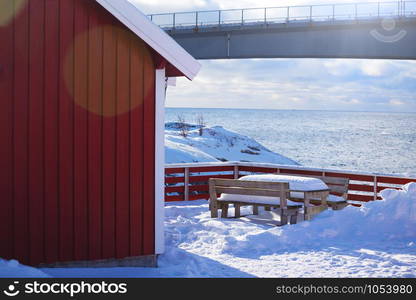 traditional norwegian wooden house rorbu to stand on the shore of the fjord and mountains in the distance. Lofoten Islands. Norway. world travel