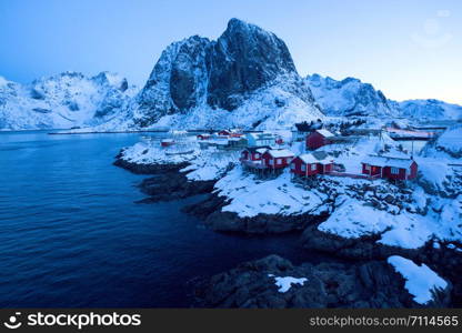 traditional norwegian wooden house rorbu to stand on the shore of the fjord and mountains in the distance. Lofoten Islands. Norway. world travel