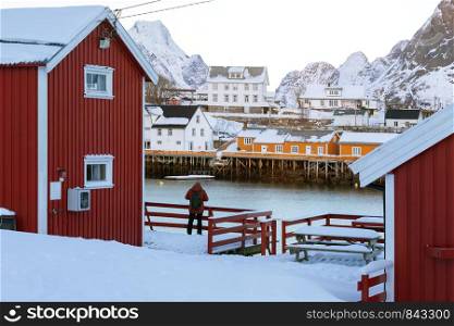 traditional norwegian wooden house rorbu to stand on the shore of the fjord and mountains in the distance. Lofoten Islands. Norway.