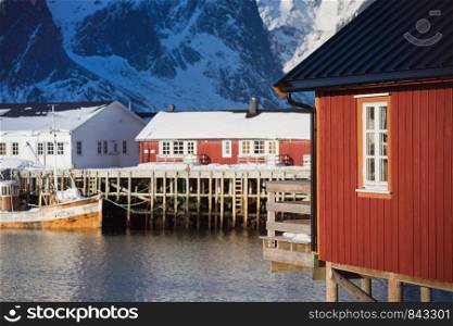 traditional norwegian wooden house rorbu to stand on the shore of the fjord and mountains in the distance. Lofoten Islands. Norway. world travel