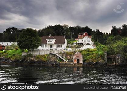 traditional norwegian wooden house standing at the fjords coast